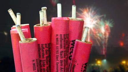 Mehrere Feuerwerkskörper sind zu sehen, im Hintergrund ein Feuerwerk.