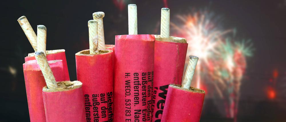 Mehrere Feuerwerkskörper sind zu sehen, im Hintergrund ein Feuerwerk.