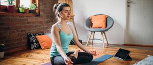 Young woman relaxing herself practicing meditation at her home