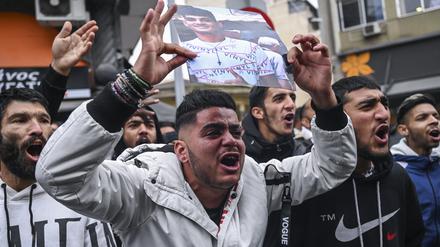 Angehörige des schwerletzten 16-Jährigen und weitere Demonstranten protestieren vor dem Gerichtsgebäude.