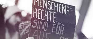 Eine Frau hält am 15.10.2015 in der Innenstadt in Hamburg während einer Demonstration gegen die Verschärfung des Asylrechts ein Schild mit der Aufschrift „Menschenrechte sind für alle da“. Zuvor hatte der Bundestag ein Paket mit umstrittenen Änderungen im Asylrecht beschlossen.