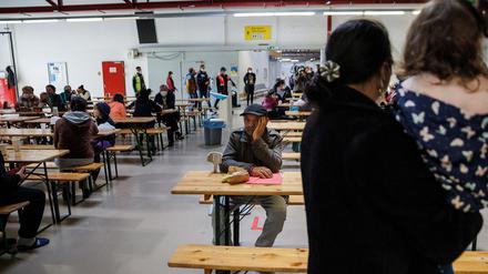 Geflüchtete Menschen aus der Ukraine sitzen im Aufenthaltsraum im Ukraine-Ankunftszentrum Tegel, Terminal C, im ehemaligen Flughafen Tegel. 