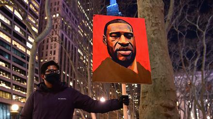 Ein Demonstrant mit einem Bild von George Floyd.