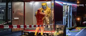 Ein Feuerwehrmann in einem Schutzanzug wird nach einem Einsatz entkontaminiert. Ausgelaufenes Desinfektionsmittel hat am Freitagabend einen Feuerwehreinsatz bei einem Kosmetikhersteller in Berlin-Charlottenburg ausgelöst.