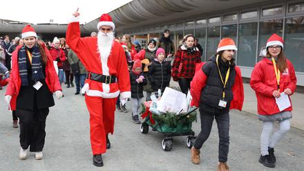 Der Weihnachtsmann und seine Helfer haben beim Weihnachtsfest der Tiere im Tierheim Berlin Wagen mit Geschenken befüllt, die gleich an die Tierheimtiere verschenkt werden.