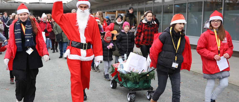 Der Weihnachtsmann und seine Helfer haben beim Weihnachtsfest der Tiere im Tierheim Berlin Wagen mit Geschenken befüllt, die gleich an die Tierheimtiere verschenkt werden.