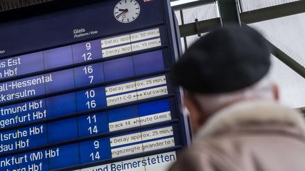 Ein Fahrgast schaut am Hauptbahnhof in Stuttgart zu einer Informationstafel der Deutschen Bahn, auf der Verspätungen bis zu 50 Minuten angezeigt werden. 