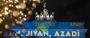 Der Schriftzug Jin - Jiyan - Azadî („Frau - Leben - Freiheit“) erleuchtet am 13.12.2022 das Brandenburger Tor aus Solidarität zu den Demonstrationen im Iran.