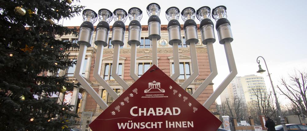 Ein Chanukka-Leuchter steht neben dem Weihnachtsbaum am Abgeordnetenhaus. Rabbiner Yehuda Teichtal übergab den Leuchter an den Präsidenten des Abgeordnetenhauses Dennis Buchner (SPD). Foto: Paul Zinken/dpa +++ dpa-Bildfunk +++