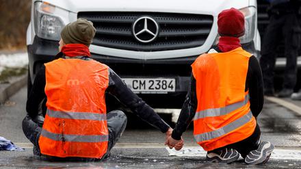 Klimaaktivisten bei einer Klebeaktion am Mittwoch in München.