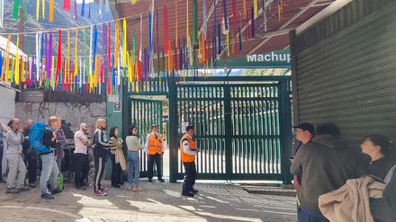 Gestrandete Touristen stehen in einer Schlange und warten.