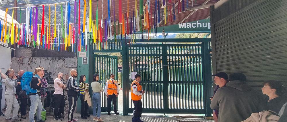 Gestrandete Touristen stehen in einer Schlange und warten.