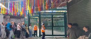 Gestrandete Touristen stehen in einer Schlange und warten.