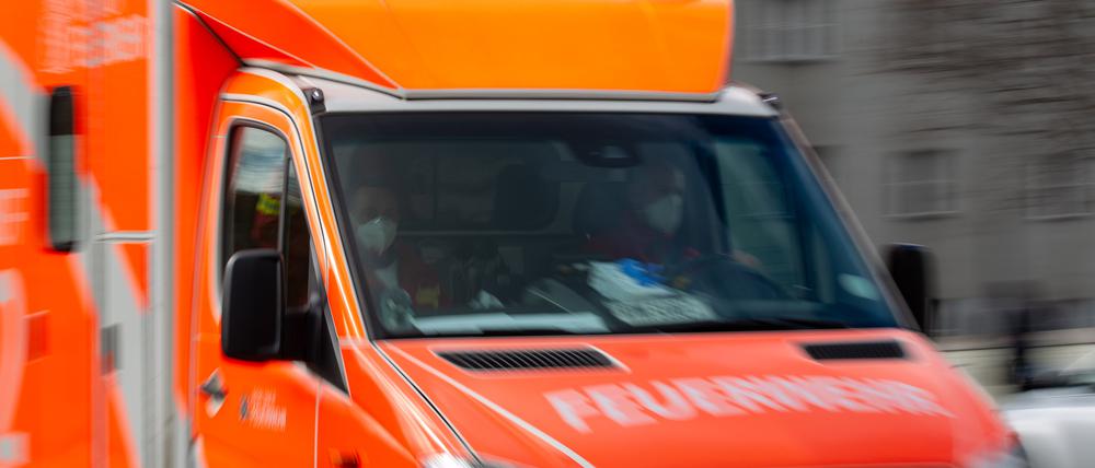Ein Rettungswagen der Feuerwehr fährt auf einer Straße.