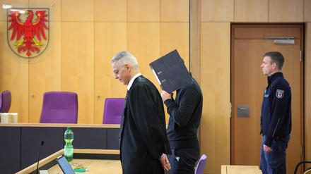 Der Angeklagte (M.) steht zu Beginn des Prozesstages im Landgericht neben seinem Verteidiger Morad Sehouli (l.)