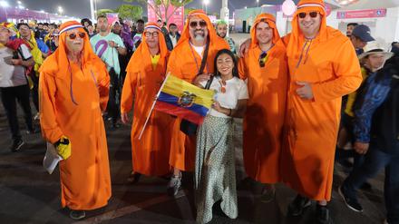 Ein ecuadorianischer Fan vor niederländischen Fans in katarischer Robe