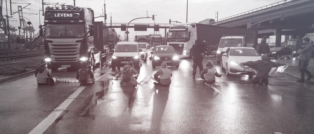 ARCHIV - 21.02.2022, Hamburg: Klimaaktivisten der Aktion ∑Aufstand der letzten Generation∑ blockieren am Morgen eine Kreuzung am Zollamt Waltershof zur Kˆhlbrandbr¸cke und zur Autobahn A7. Foto: Christian Charisius/dpa +++ dpa-Bildfunk +++