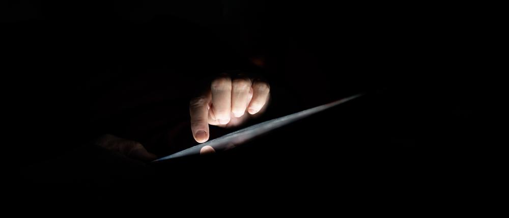 Eine Person bei der Nutzung eines Tablets (Symbolfoto). Ermittler aus Hessen können einen Erfolg im Kampf gegen Kindesmissbrauch vermelden: Drei Darknet-Plattformen wurden abgeschaltet.