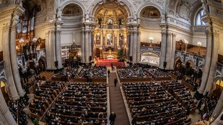 Besucher der Christvesper sitzen im Berliner Dom. 