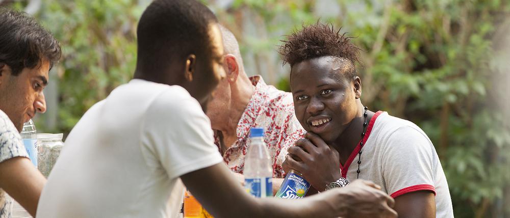 Grillfest des Vereins akinda e.V. Berlin - ehrenamtliche Vormünder für minderjährige unbegleitete Flüchtlinge. Hier: Nazir, 16 Jahre alt Flüchtling aus Libyen geboren in Benin im Gespräch mit seinem Freund.