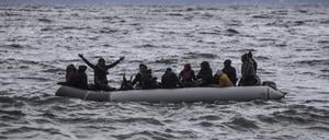 Migranten aus Afrika kommen in einem Schlauchboot am Strand in Lesbos an.