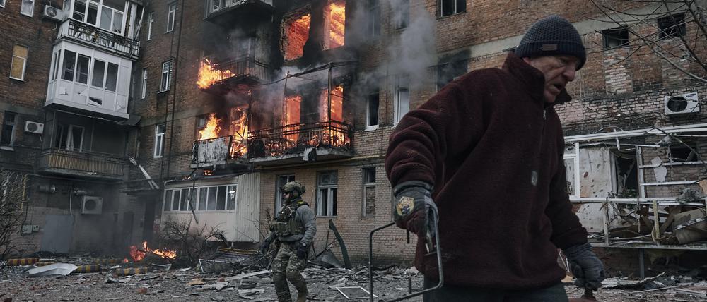 Ein Anwohner verlässt sein Wohnhaus, das nach einem Beschuss in Flammen steht.