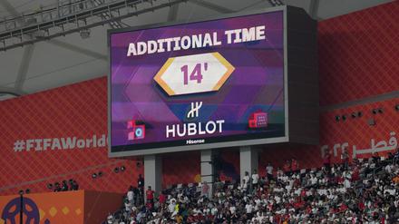 ARCHIV - 21.11.2022, Katar, Doha: Fußball, WM 2022 in Katar, England - Iran, Vorrunde, Gruppe B, Chalifa International Stadion, Die Großbildleinwand zeigt die vierzehnminütige Nachspielzeit am Ende der ersten Halbzeit. (zu dpa: «Abseitstechnik, Nachspielzeit, Taktik: WM-Lehren für die Bundesliga») Foto: Martin Rickett/PA Wire/dpa +++ dpa-Bildfunk +++
