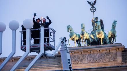 Christian Lindner (FDP, r.), Bundesminister der Finanzen, und Rabbiner Yehuda Teichtal, Vorsitzender des Chabad Jüdischen Bildungszentrums, entzünden das erste Licht am Chanukka-Leuchter vor dem Brandenburger Tor.