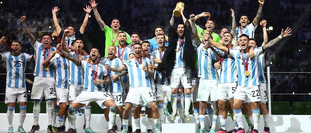 Lionel Messi reckt den WM-Pokal in die Höhe.