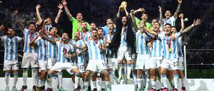 Lionel Messi reckt den WM-Pokal in die Höhe.