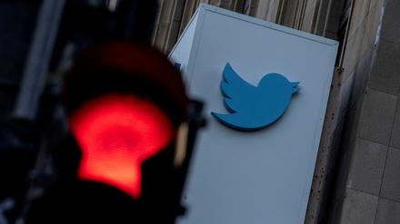 Das Twitter-Logo ist hinter einer roten Ampel zu sehen.