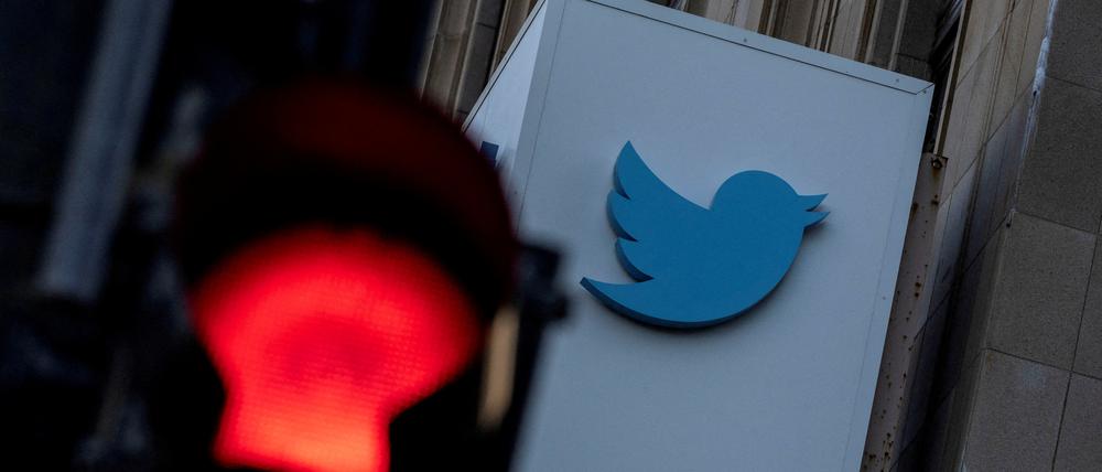 Das Twitter-Logo ist hinter einer roten Ampel zu sehen.