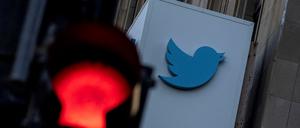 Das Twitter-Logo ist hinter einer roten Ampel zu sehen.