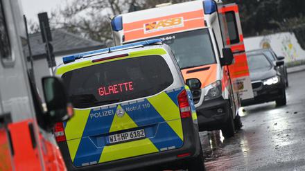 Ein Polizeiauto steht am 19. Dezember 2022 in Kassel neben einem Krankenwagen und warnt vor Glätte und Glatteis.