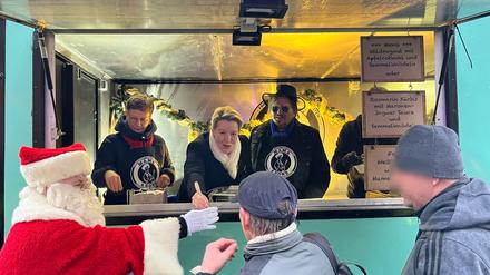Frank Zander verteilt Essen an Bedürftige. Links daneben Franziska Giffey und der Weihnachtsmann „Bernd“. 