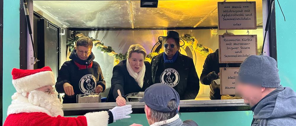 Frank Zander verteilt Essen an Bedürftige. Links daneben Franziska Giffey und der Weihnachtsmann „Bernd“.