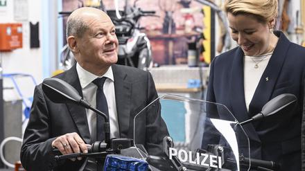 19.12.2022, Berlin: Bundeskanzler Olaf Scholz (SPD) sitzt bei einem Besuch vom BMW Group Motorradwerk in Spandau auf einem Polizei-Elektro-Roller, daneben steht die Regierende Bürgermeisterin von Berlin Franziska Giffey (SPD) . Es stehen Themen wie Fachkräfteausbildung in der Industrie und innovative Elektromobilität im Fokus des Besuchs. Foto: Jens Kalaene/dpa +++ dpa-Bildfunk +++