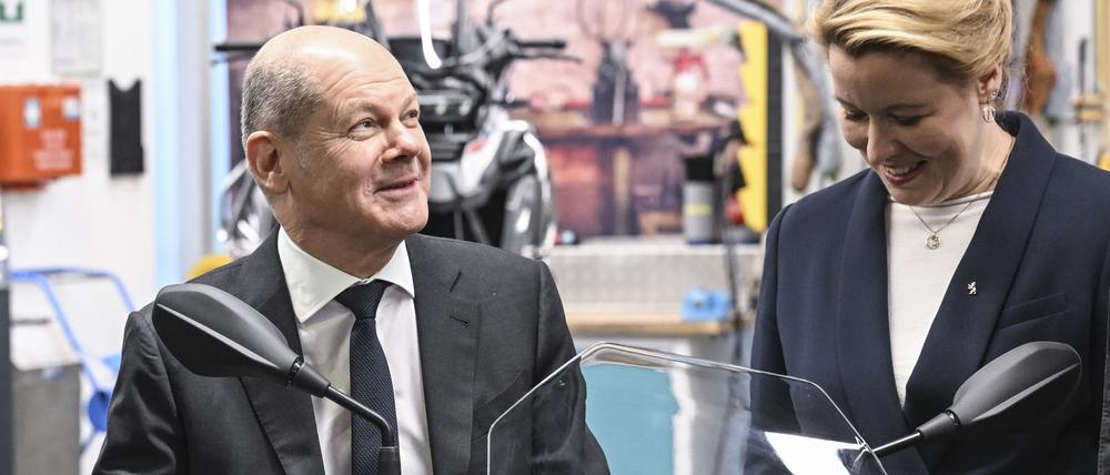 19.12.2022, Berlin: Bundeskanzler Olaf Scholz (SPD) sitzt bei einem Besuch vom BMW Group Motorradwerk in Spandau auf einem Polizei-Elektro-Roller, daneben steht die Regierende Bürgermeisterin von Berlin Franziska Giffey (SPD) . Es stehen Themen wie Fachkräfteausbildung in der Industrie und innovative Elektromobilität im Fokus des Besuchs. Foto: Jens Kalaene/dpa +++ dpa-Bildfunk +++