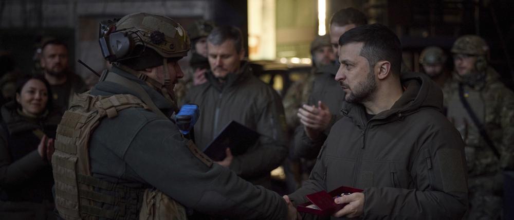 Auf diesem vom Pressebüro des ukrainischen Präsidenten zur Verfügung gestellten Foto zeichnet Wolodymyr Selensky (r), Präsident der Ukraine, einen Soldaten am Ort der schwersten Kämpfe aus.