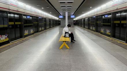Ein Pendler trägt eine Schutzmaske, während er in einer U-Bahn-Station auf einen Zug wartet. Der Ausbruch der Coronavirus-Krankheit (COVID-19) hält in Shanghai, China, am 20. Dezember 2022 an.