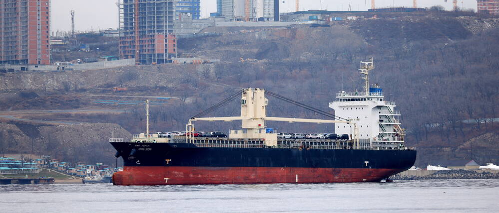 Ein Frachtschiff liegt im Hafen von Wladiwostok und wartet darauf, entladen zu werden.