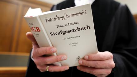 Richter im Gerichtssaal mit Strafgesetzbuch.