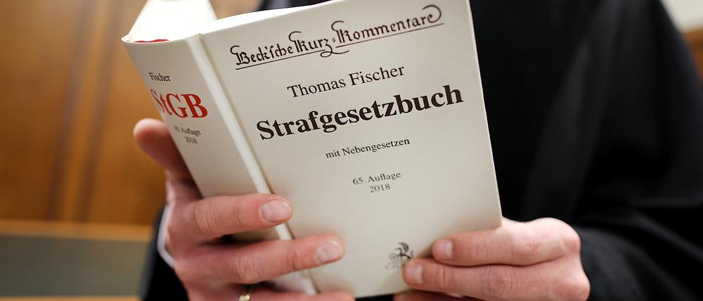 Richter im Gerichtssaal mit Strafgesetzbuch.