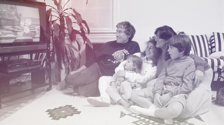 The Arenstein family watches a video on their television.
