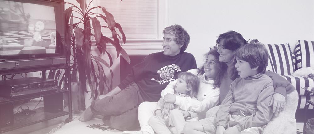 The Arenstein family watches a video on their television.