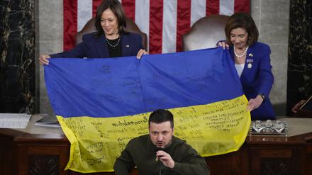 Wolodymyr Selenskyj, Präsident der Ukraine, spricht vor einer überreichten ukrainischen Flagge, die von den Frontsoldaten in Bachmut signiert wurde.