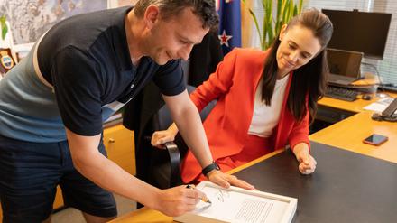 Jacinda Ardern und der Oppositionspolitiker David Seymour unterzeichnen das Protokoll.