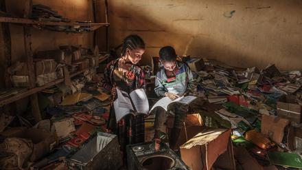 Kinder betrachten Bücher in der Bibliothek einer Grundschule im Dorf Bisober in Äthiopien.