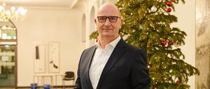 Dietmar Woidke (SPD), Ministerpräsident des Landes Brandenburg, steht im Foyer der Staatskanzlei vor dem Weihnachtsbaum.