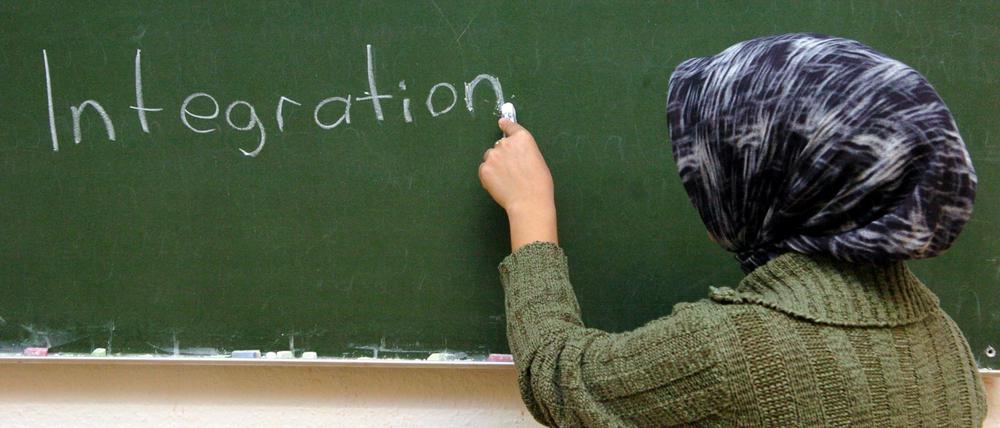 ARCHIV - Eine türkische Frau schreibt im Schulungsraum der interkulturellen Frauenbegegnungsstätte "verikom" in Hamburg-Wilhelmsburg das Wort "Integration" an die Tafel (Archivfoto/Illustration vom 24.11.2004). Zuwanderer haben «dramatisch» schlechte Chancen in der Schule und auf dem Arbeitsmarkt. Zu diesem Ergebnis kommt die Integrationsbeauftragte der Bundesregierung, Maria Böhmer (CDU), in ihrem am Mittwoch (19.12.2007) vorgelegten Bericht, der sich mit den bundesweit 15 Millionen Menschen aus Zuwandererfamilien befasst. Foto: Patrick Lux dpa/lbn +++(c) dpa - Bildfunk+++ | Verwendung weltweit